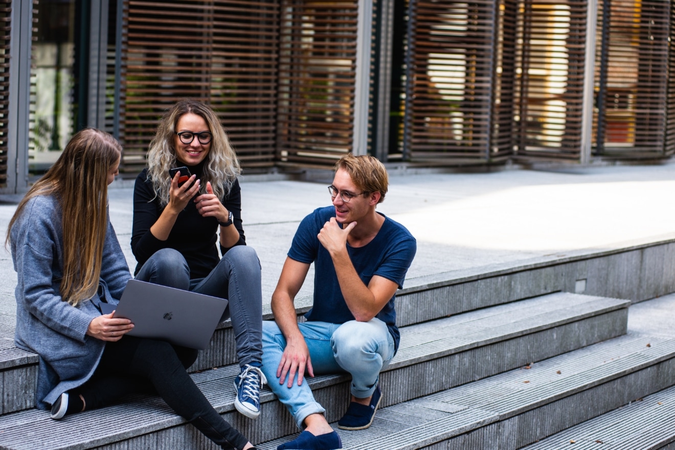 Three young people sitting on stairs