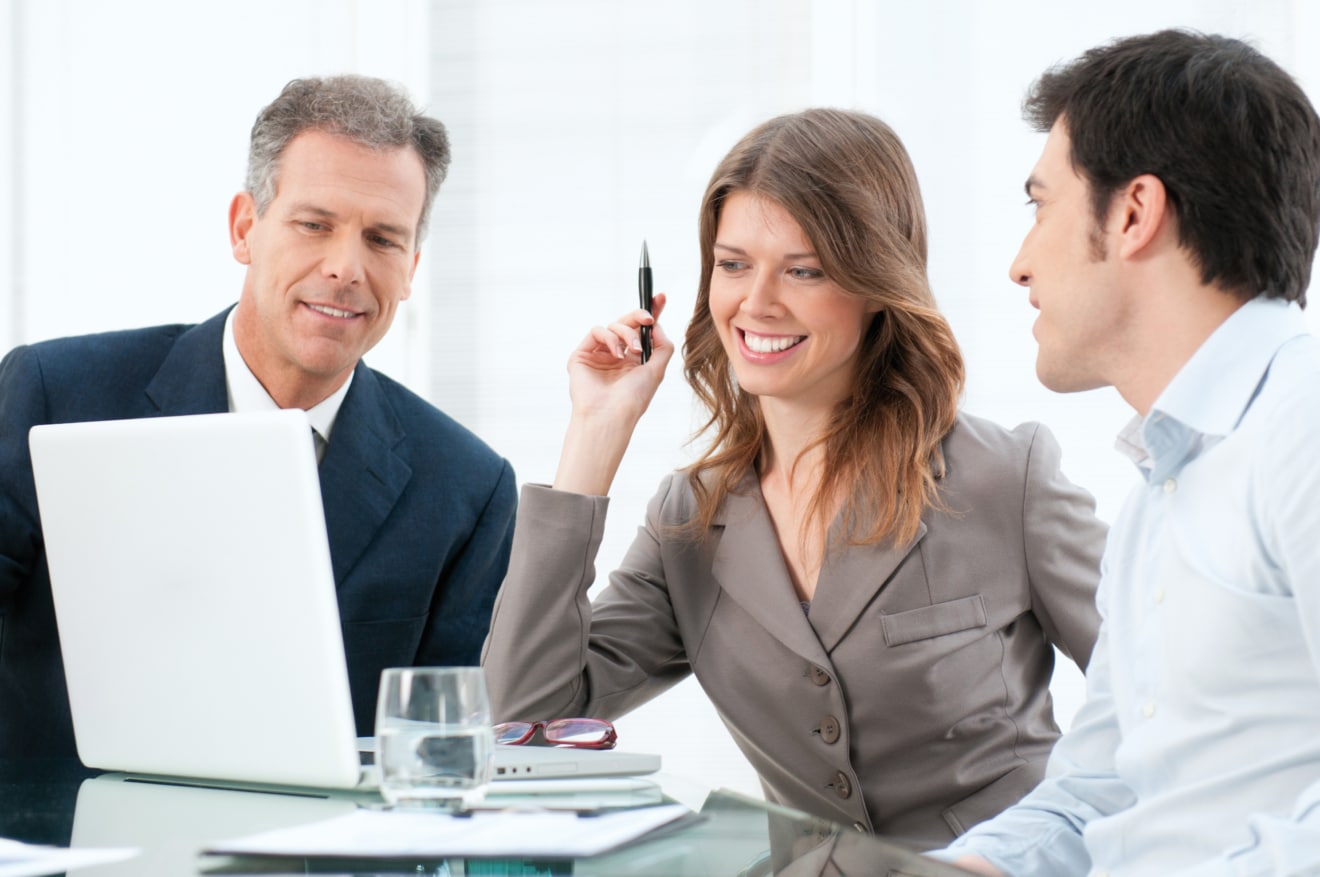 Smiling business team working together at laptop computer in the office